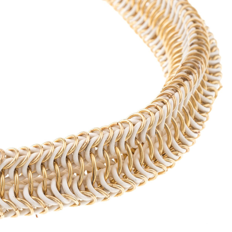 Detail of the golden rings of the triangular elastic necklace